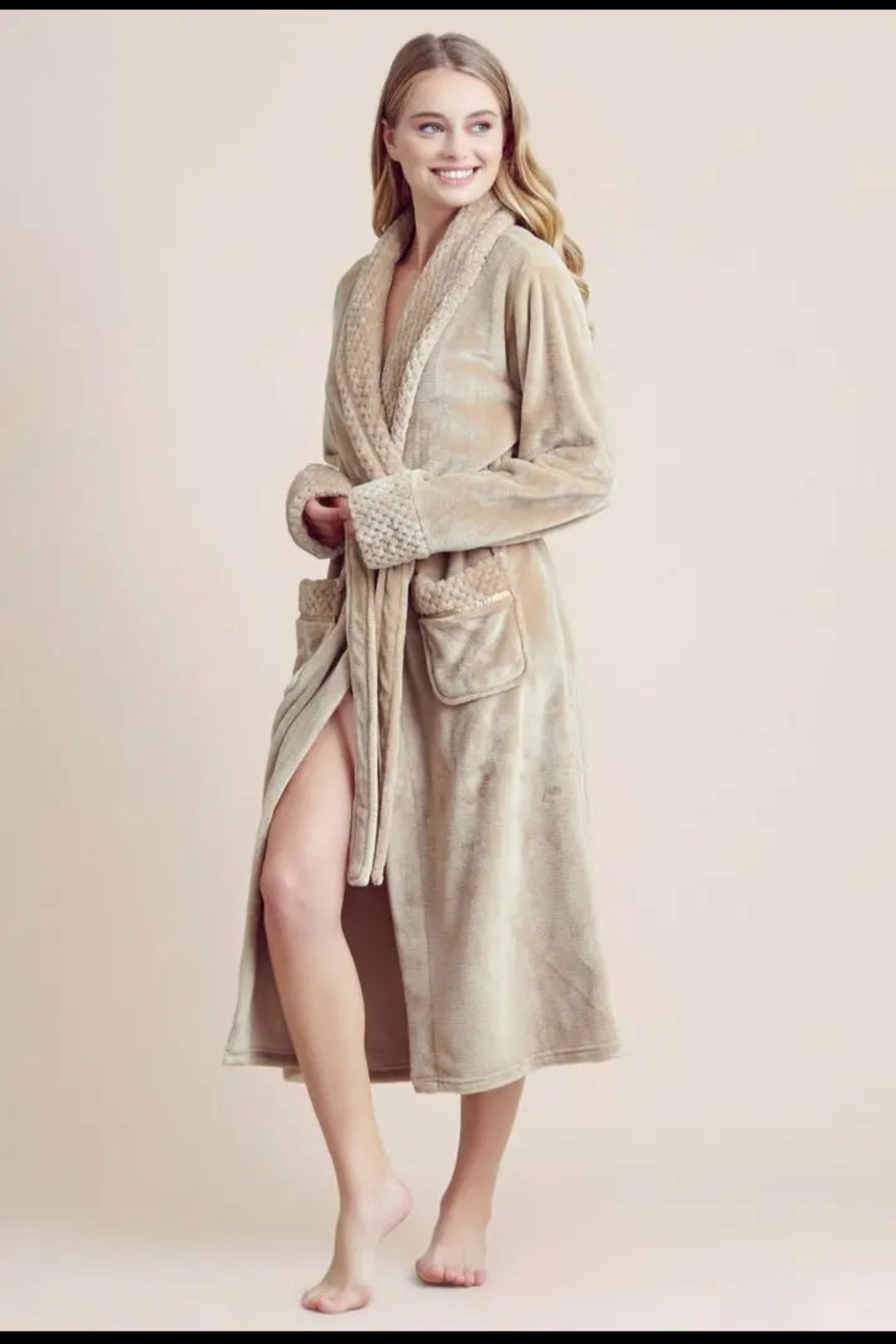 Woman wearing a beige robe on a plain background