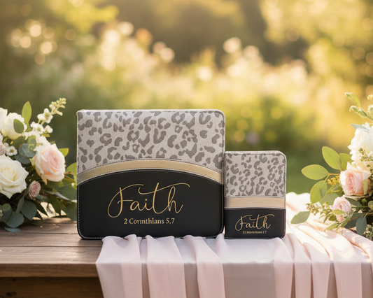 Two prayer books with 'Faith' text on a table outdoors with flowers.