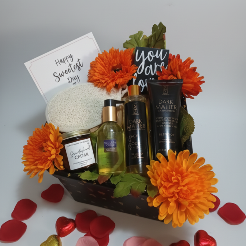 Gift basket with skincare products, flowers, and a card on a white background