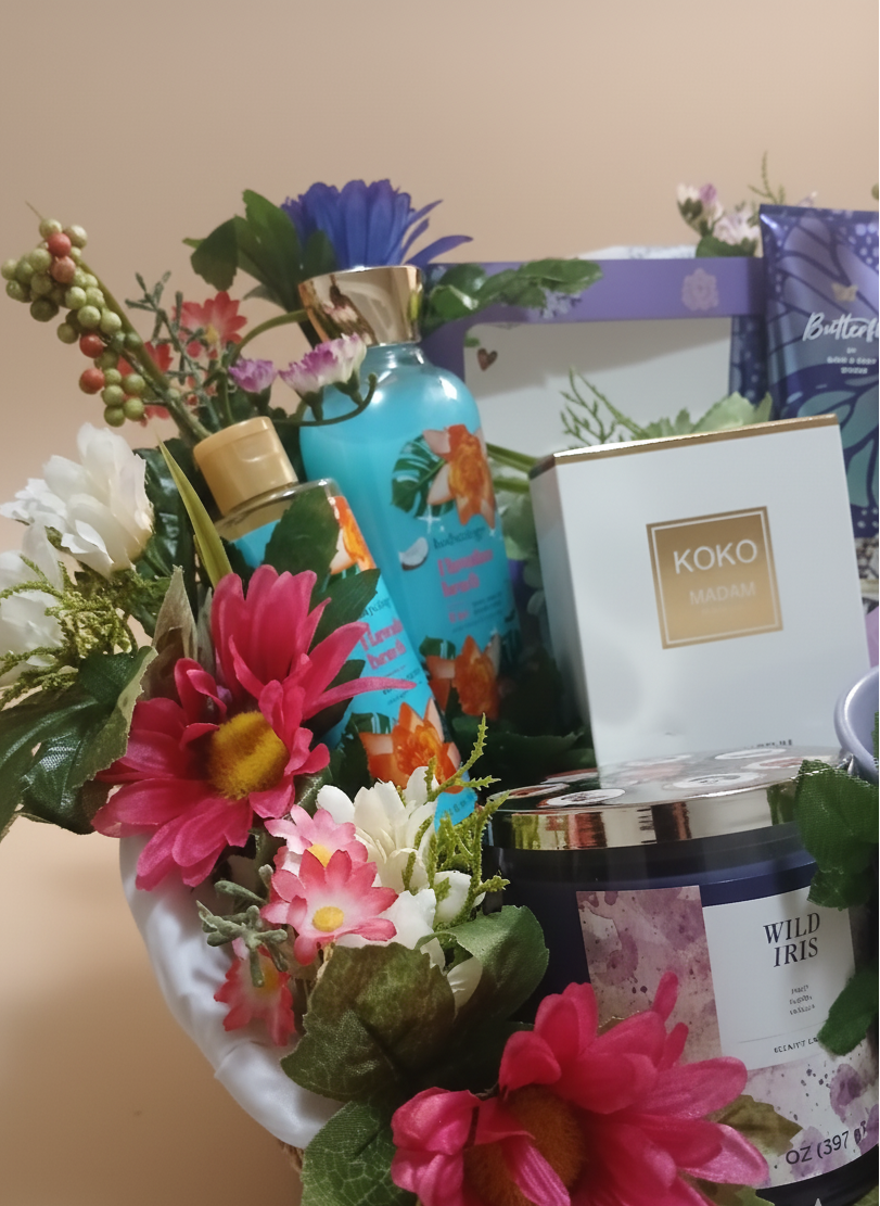 Gift basket with flowers, bath products, and a candle on a beige background