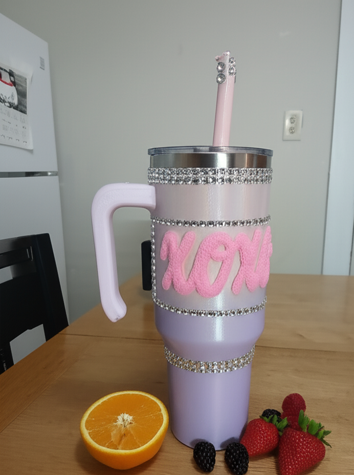 Pink tumbler with rhinestone details on a wooden table with fruit