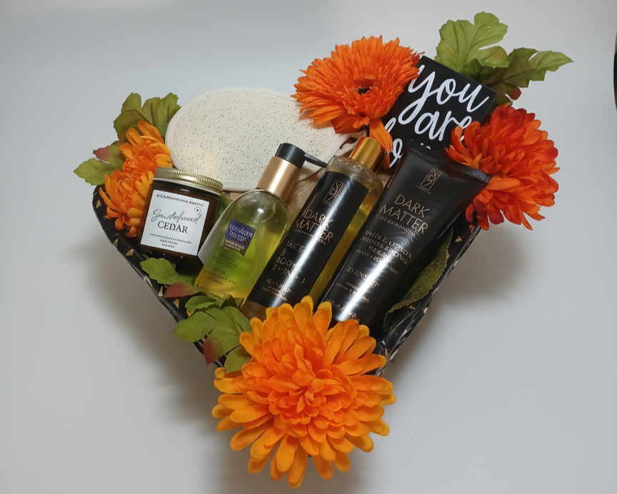 Gift set with skincare products and orange flowers on a white background