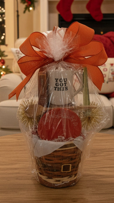 Gift basket with a mug and decorative items on a table, Christmas decorations in the background