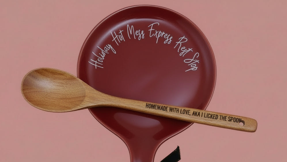 Red pan with wooden spoon on a pink background