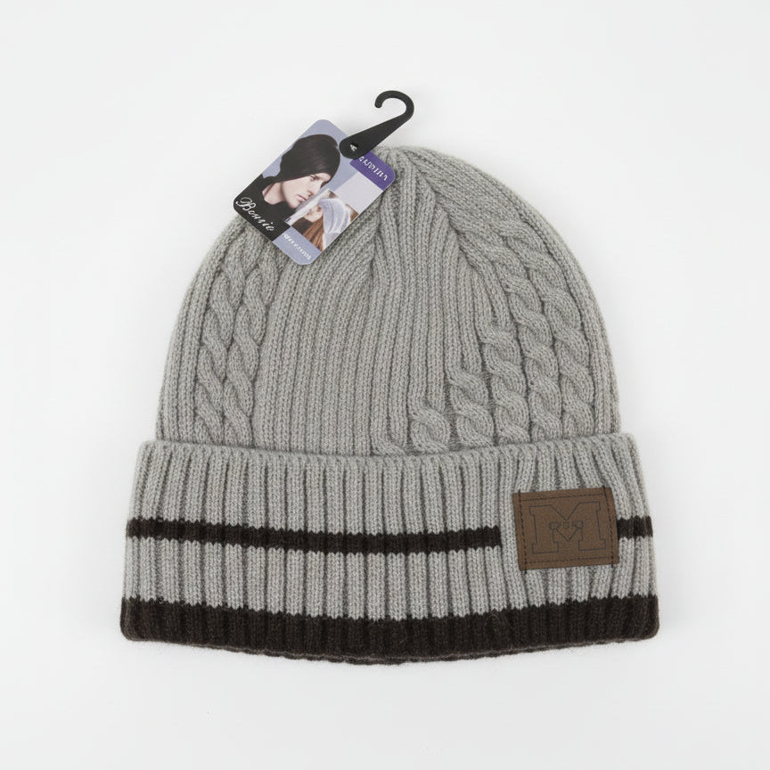 Gray knit beanie with black band and brown label on a white background