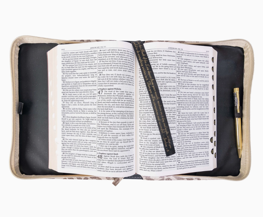 Open book with a ruler and pen inside a cushioned cover on a white background