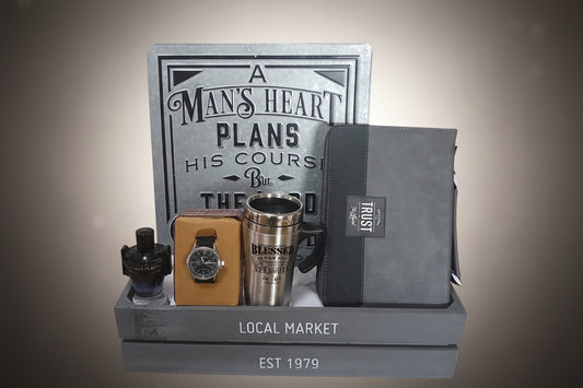 Collection of men's accessories including a watch, tumbler, and wallet on a stand with motivational quote plaque.