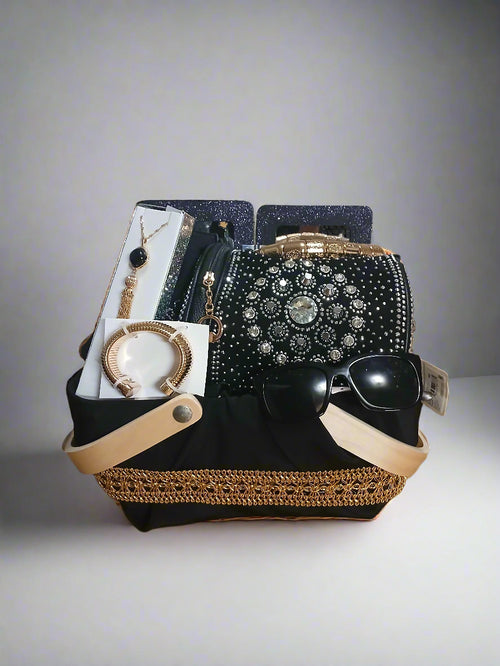 Black handbag with gold accents and jewelry on a wooden surface