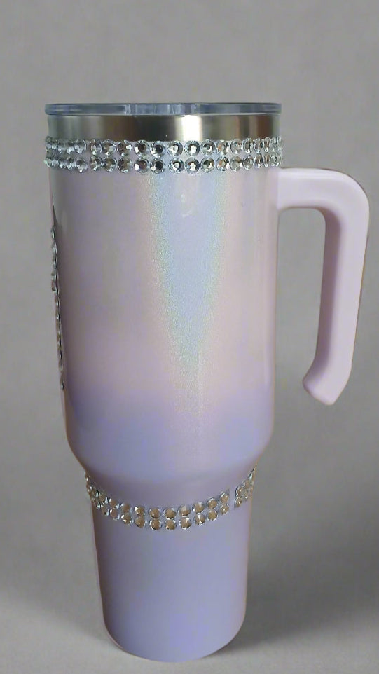 Pink thermos with decorative bling on a wooden surface