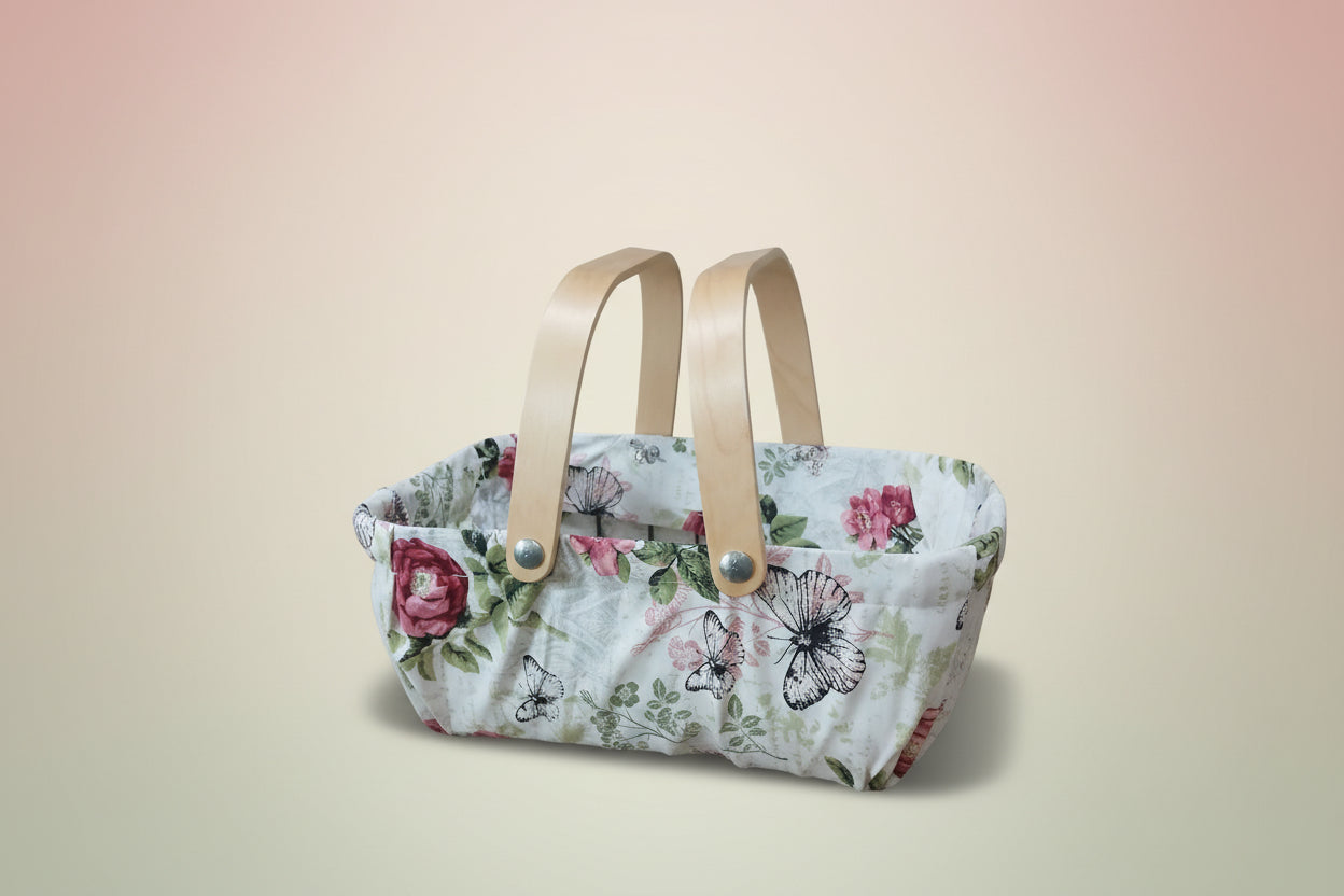 Floral-patterned bag with wooden handles on a wooden surface