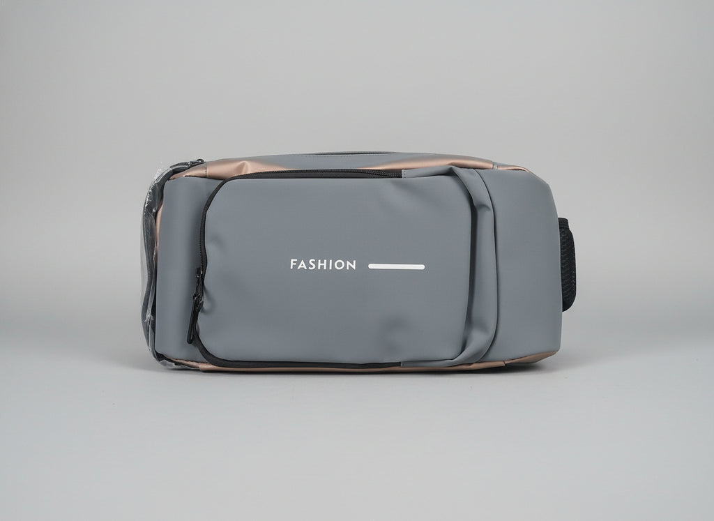 Gray crossbodyl bag with 'FASHION' text on a marble surface