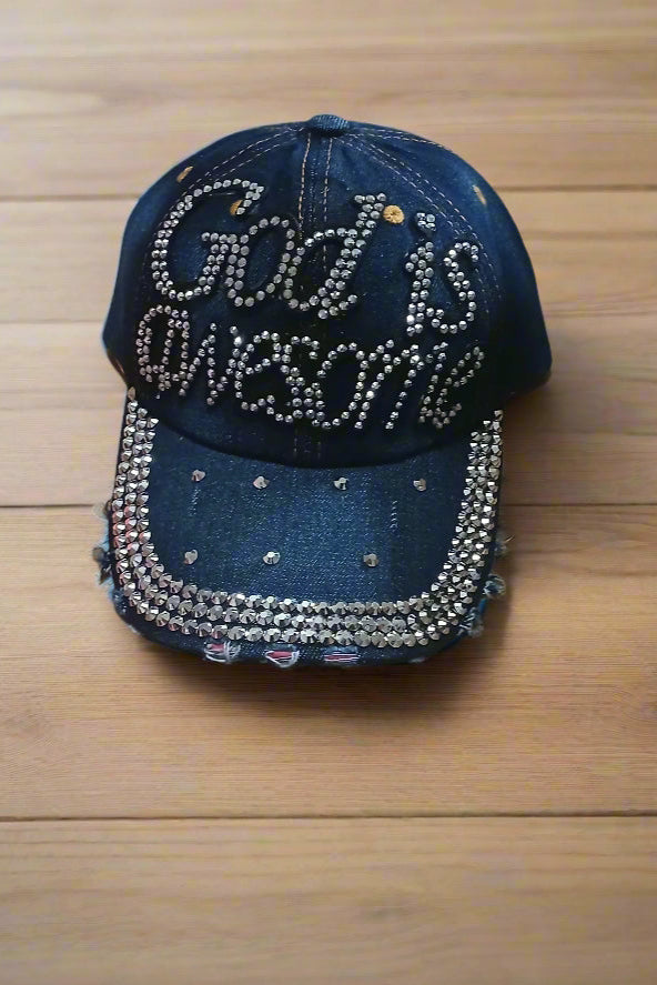 Denim cap with 'God is Awesome' text and rhinestone embellishments on a wooden surface
