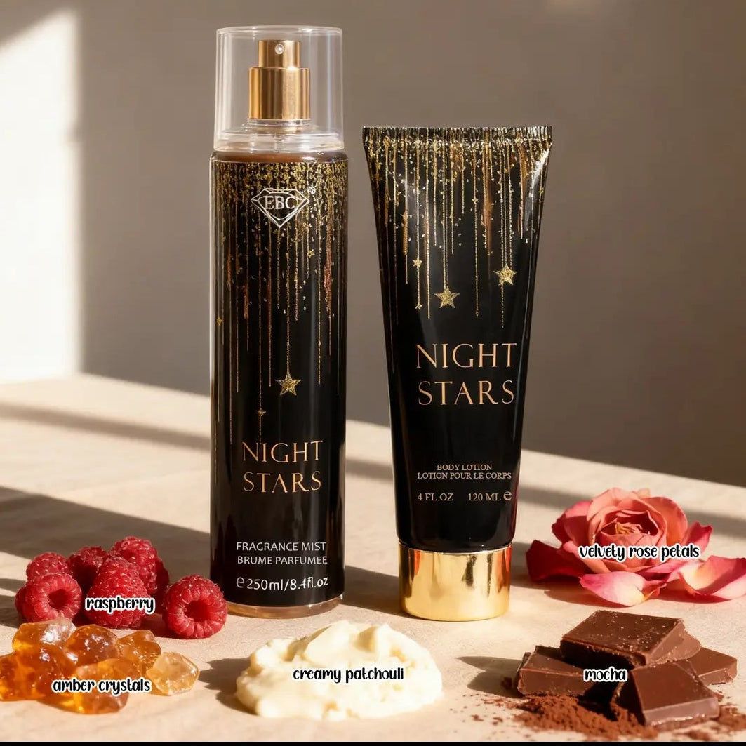 Victoria's Secret Night Stars body care set featuring a tall spray bottle and a matching tube, both in black with gold lettering and star details, styled with red roses and chocolate on a light surface.