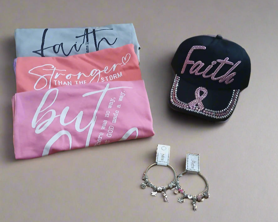Three folded shirts with motivational phrases, a black cap with 'Faith' text, and two bracelets on a neutral background.