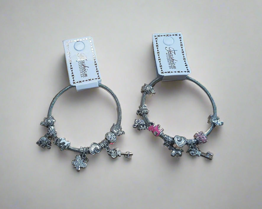 Two decorative hair ties with charms on a beige background
